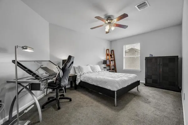 a bedroom with a bed a desk and chair