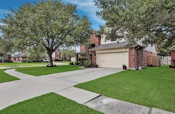 a view of a house with a yard and large tree