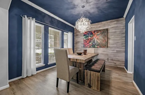 a view of a dining room with furniture a chandelier and wooden floor