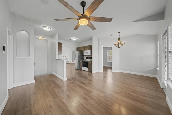 a view of a livingroom with wooden floor and a ceiling fan
