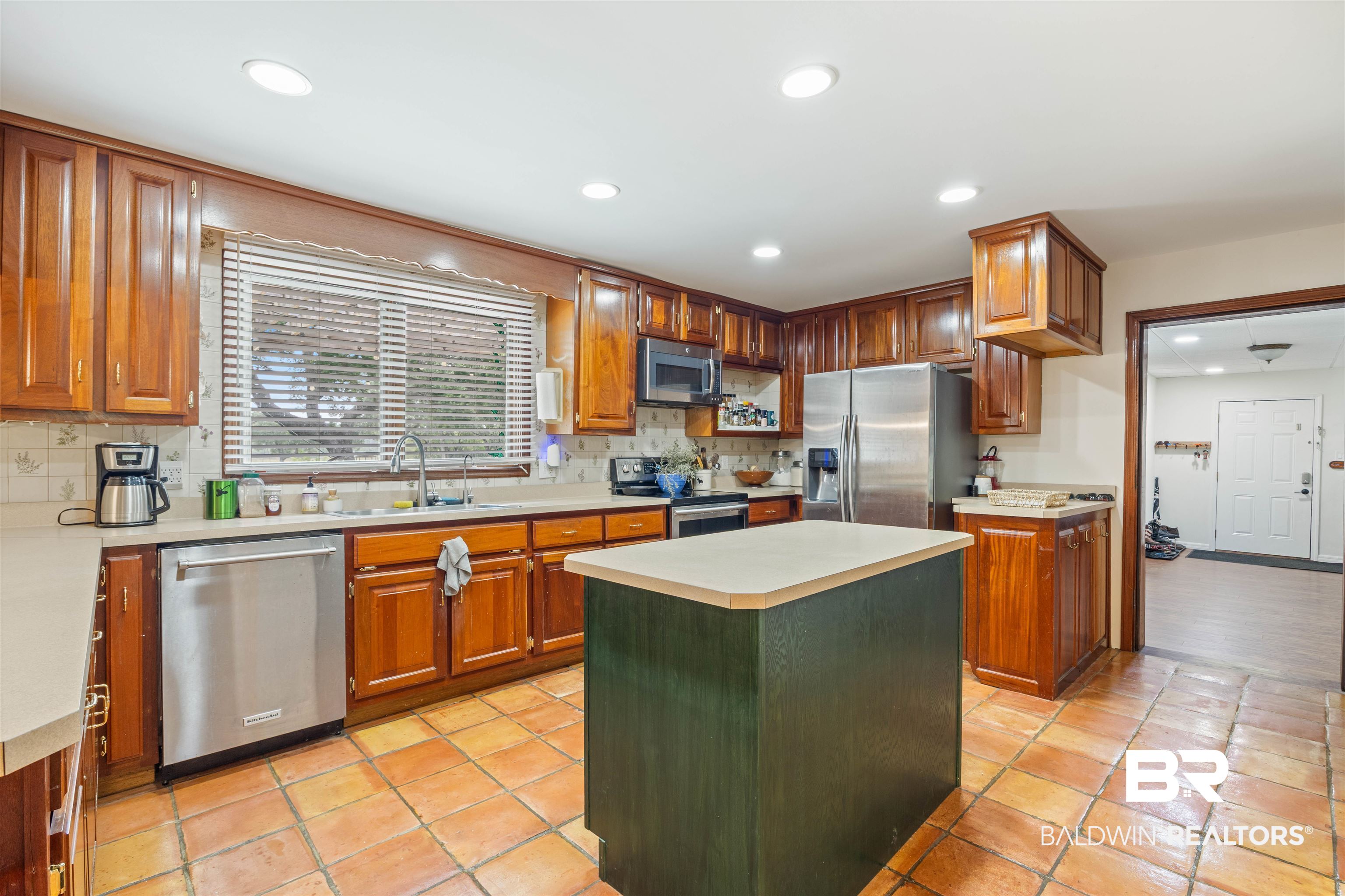 13677 Rebel Road Coden, AL 36523 - Photo 11 of 61 Kitchen featuring wood cabinetry, stainless steel appliances, a center island with a light countertop, and tile flooring