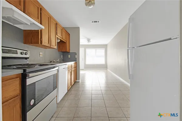 a kitchen with stainless steel appliances granite countertop a refrigerator and a stove