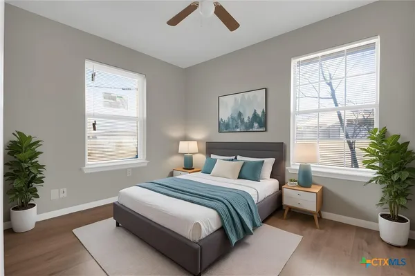 a bedroom with a large bed and a potted plant