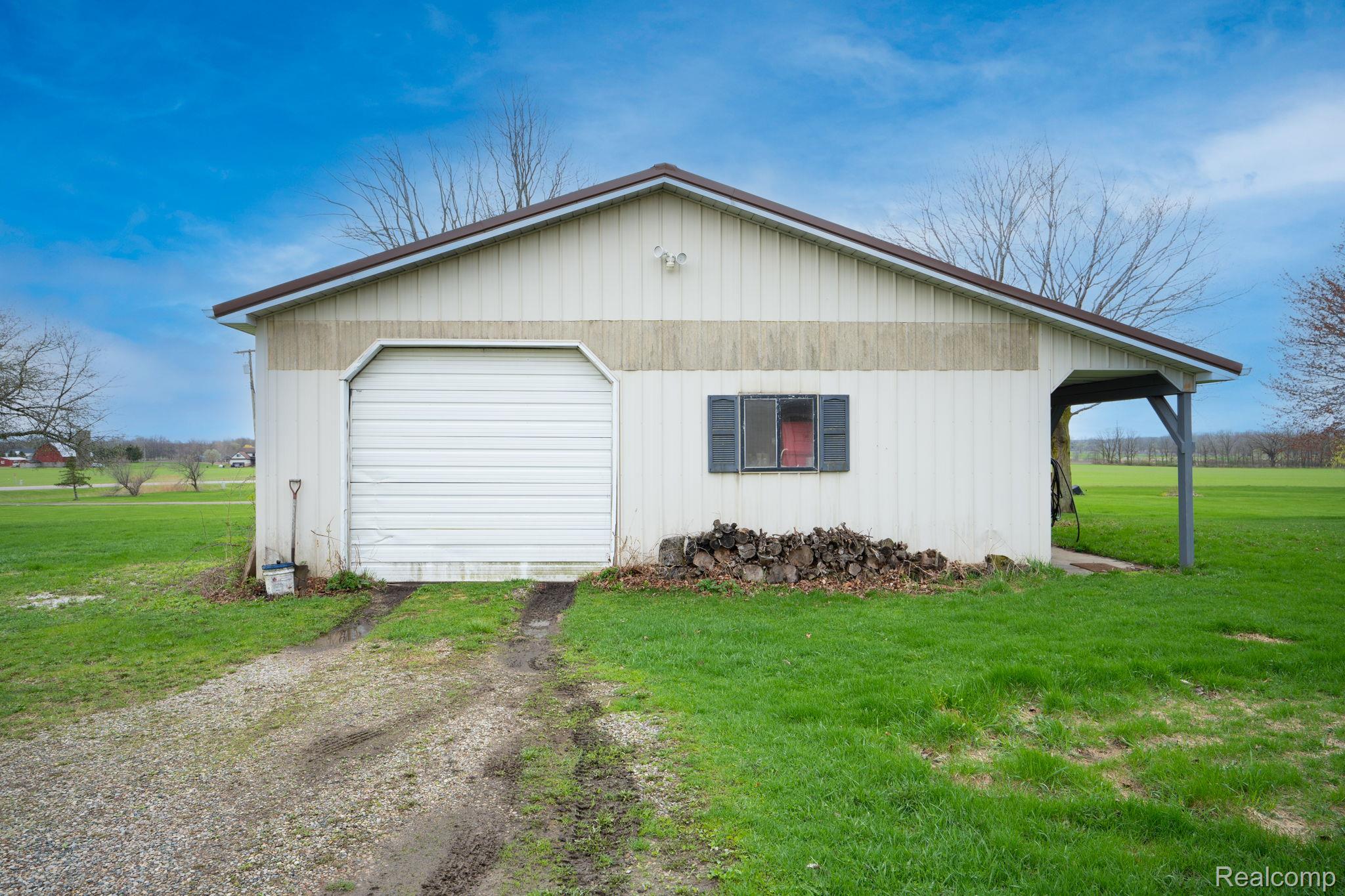 2890 Graham Road Imlay City, MI 48444 - Photo 28 of 33 View of property exterior with a lawn, driveway, and a garage