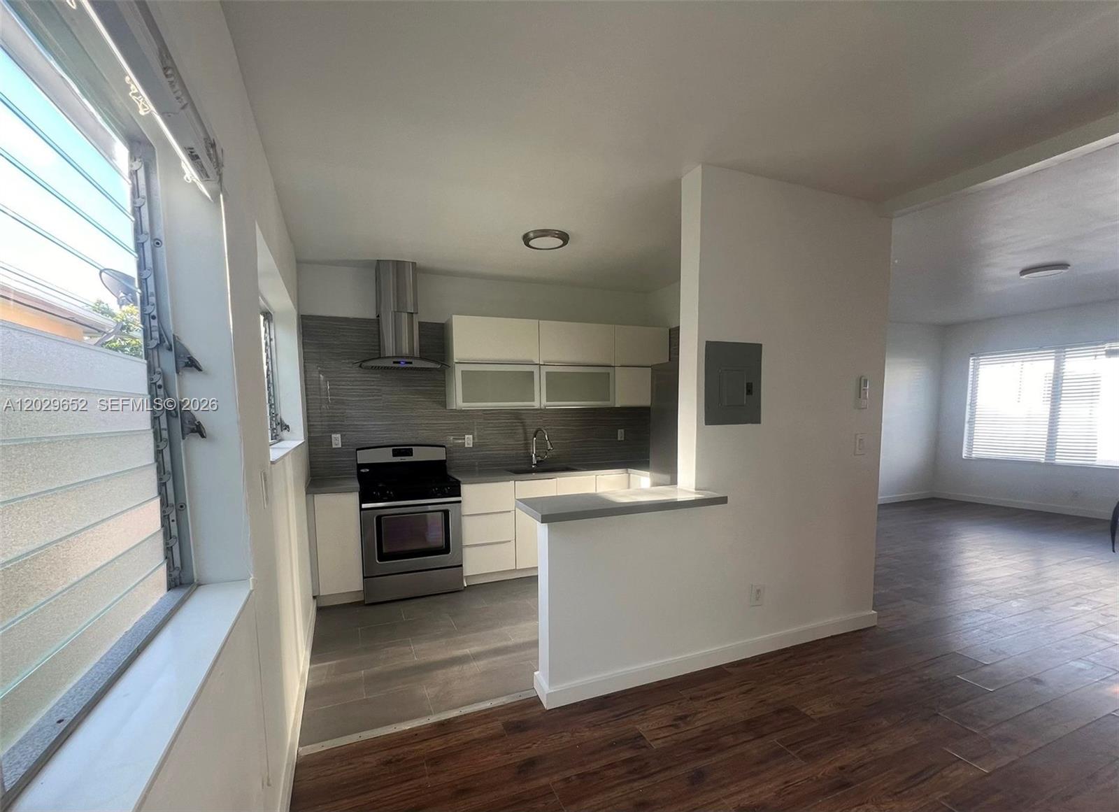855 80th Street, Unit 4 Miami Beach, FL 33141 - Photo 9 of 16 a kitchen with a wooden floor and a stove top oven