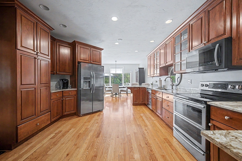 270 Mendon Road Sutton, MA 01590 - Photo 10 of 42 a kitchen with stainless steel appliances granite countertop a refrigerator a stove top oven a sink dishwasher and wooden cabinets with wooden floor