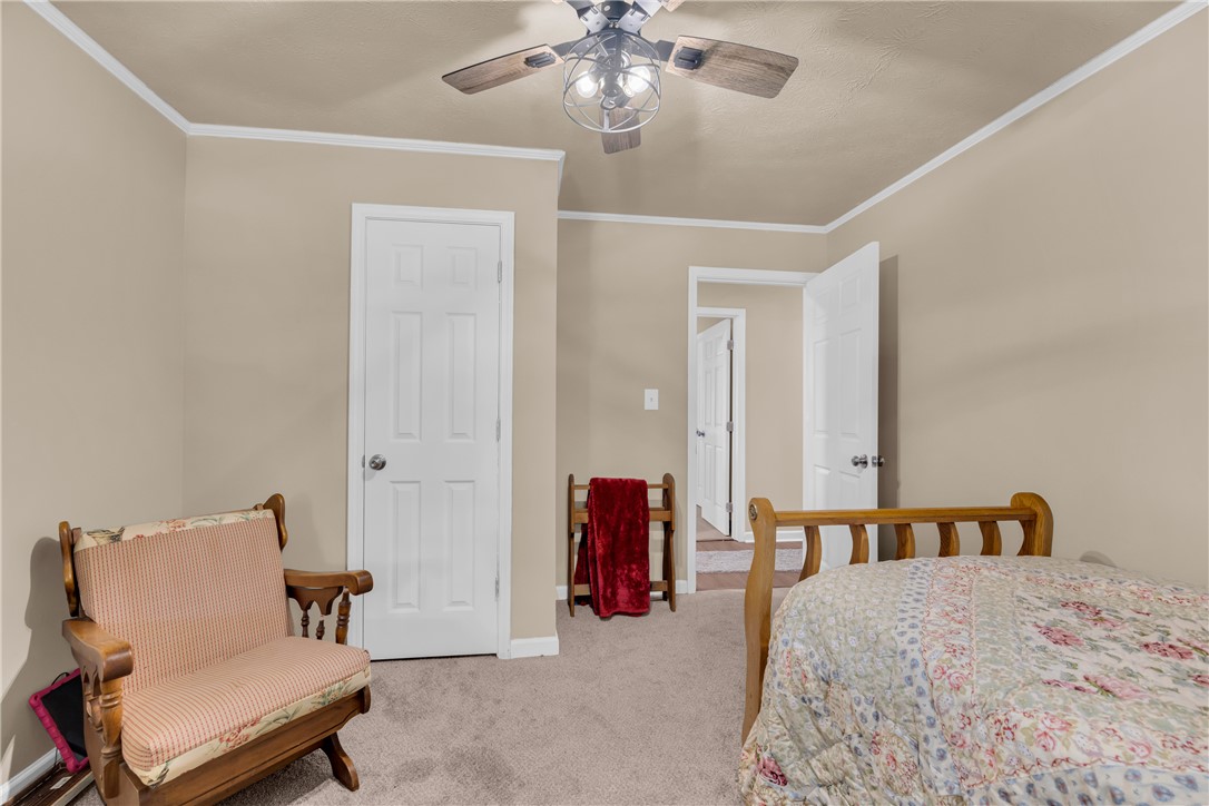 3030 Smith McGee Road Iva, SC 29655 - Photo 28 of 46 A well-lit bedroom features plush carpeting and a modern ceiling fan, offering comfortable living.