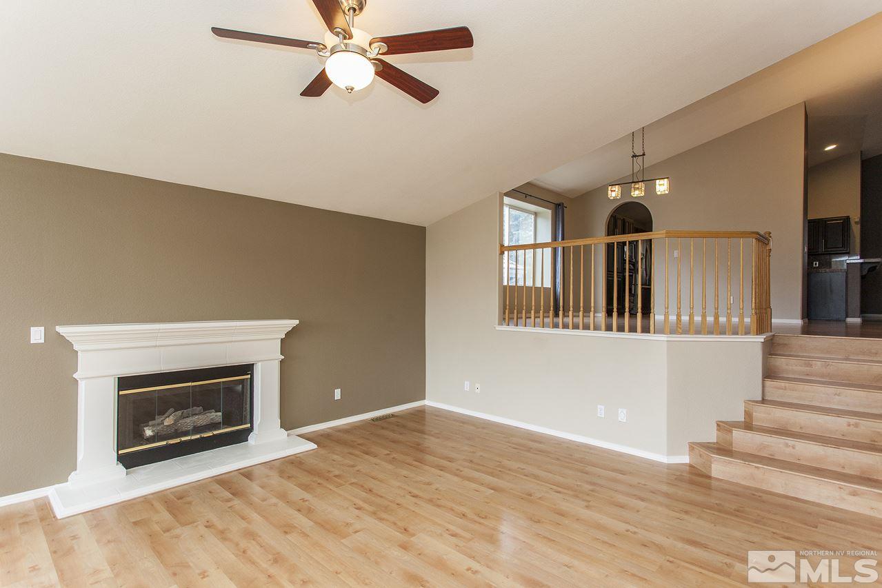 6020 Sunrise Meadows Loop Reno, NV 89519 - Photo 5 of 30 a view of an empty room with wooden floor fireplace and a window