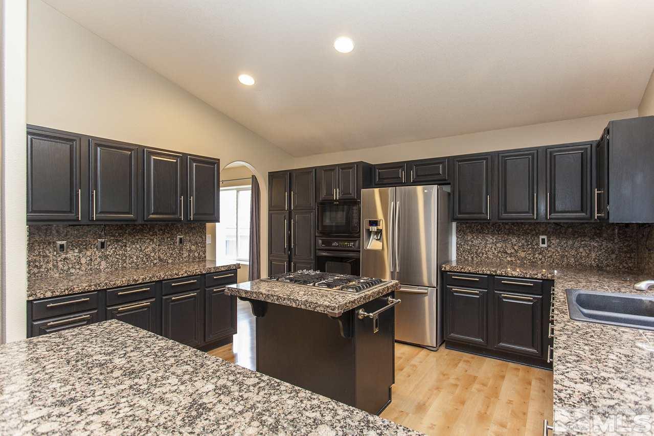 6020 Sunrise Meadows Loop Reno, NV 89519 - Photo 8 of 30 a kitchen with granite countertop stainless steel appliances and wooden cabinets