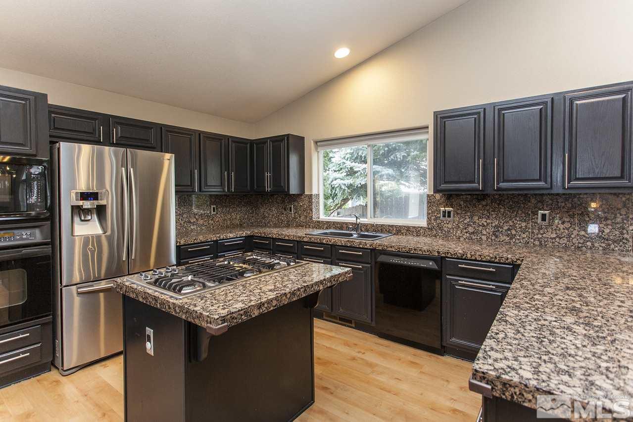 6020 Sunrise Meadows Loop Reno, NV 89519 - Photo 9 of 30 a kitchen with granite countertop stainless steel appliances a stove refrigerator sink and cabinets
