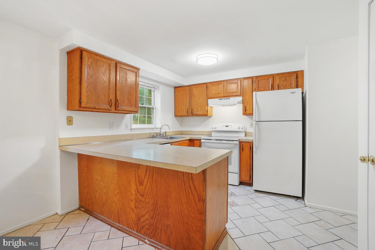 13221 Black Walnut Court Silver Spring, MD 20906 - Photo 10 of 30 a kitchen with refrigerator cabinets and a window