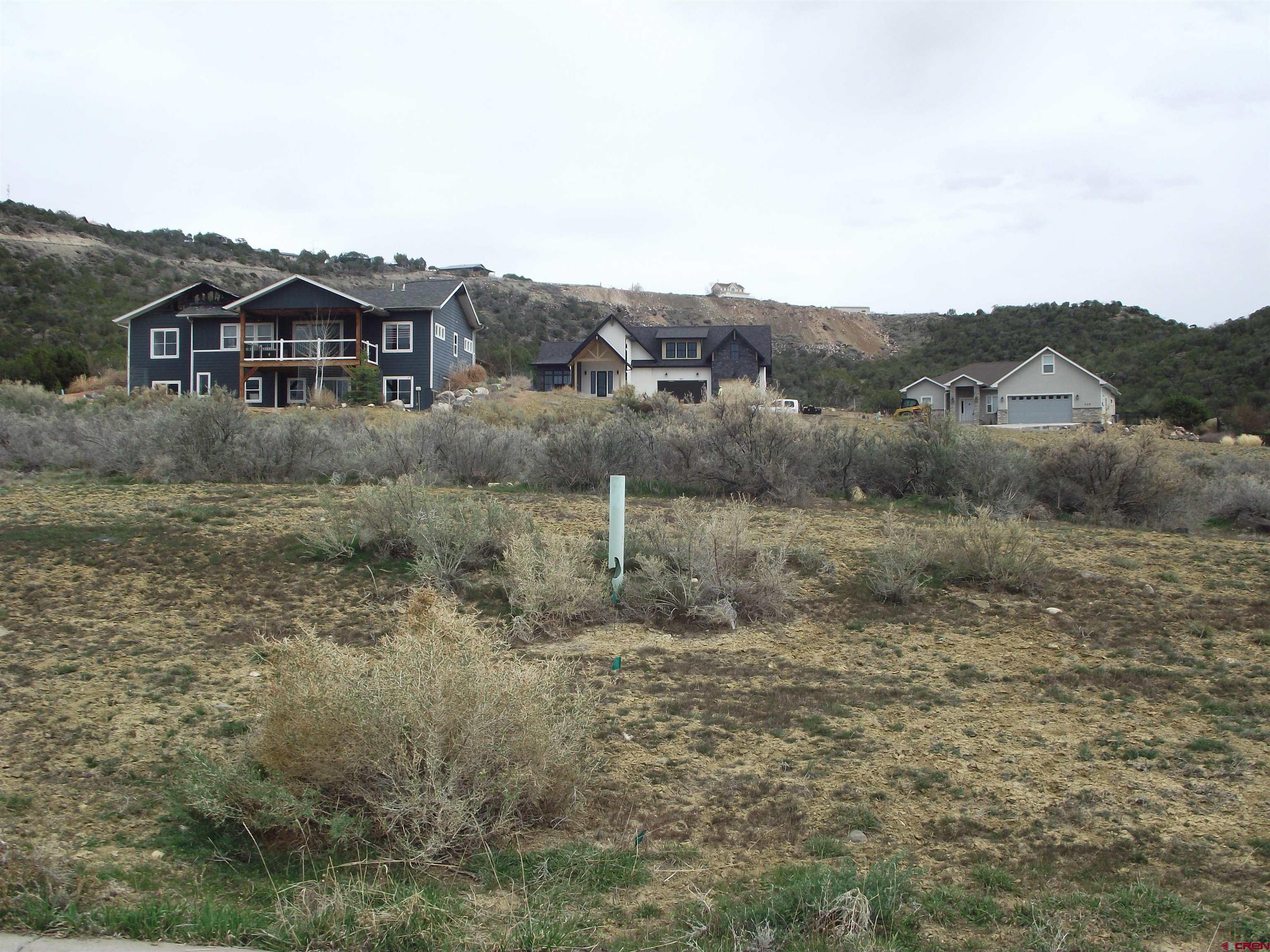 725 Southeast Pinyon Street Cedaredge, CO 81413 - Photo 5 of 13 a view of a big house with a mountain in the background