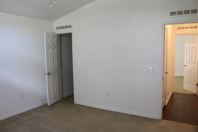 an empty room with windows and closet