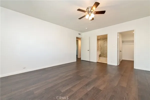 a view of a room with wooden floor and a ceiling fan