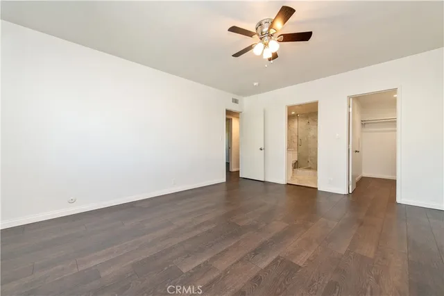 a view of a room with wooden floor and a ceiling fan