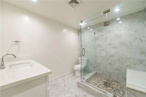 a bathroom with a sink a toilet and shower