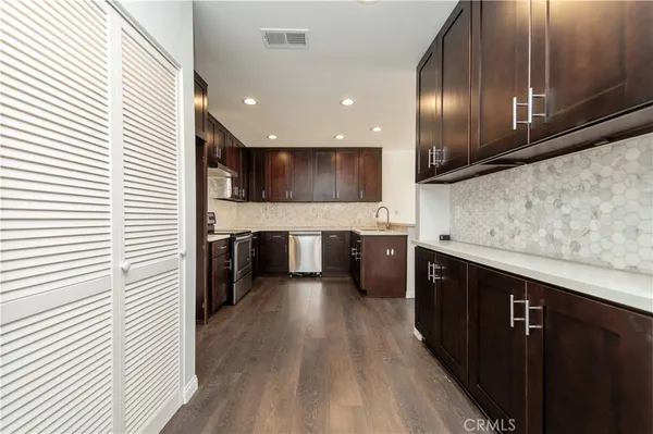 a kitchen with stainless steel appliances granite countertop wooden cabinets a sink and a stove