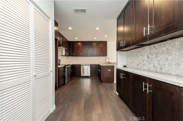 a kitchen with stainless steel appliances granite countertop wooden cabinets a sink and a stove