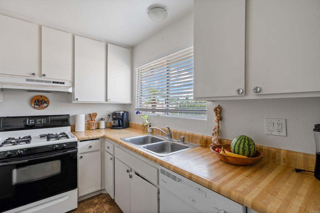4533 Sunrise Oceanside, CA 92056 - Photo 12 of 24 a kitchen with granite countertop a sink a stove and cabinets