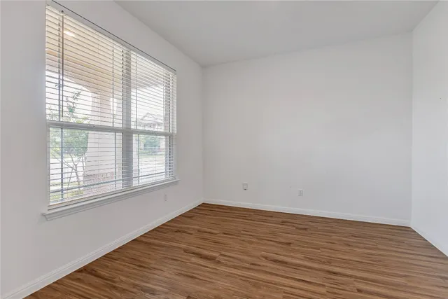 wooden floor in an empty room with a window