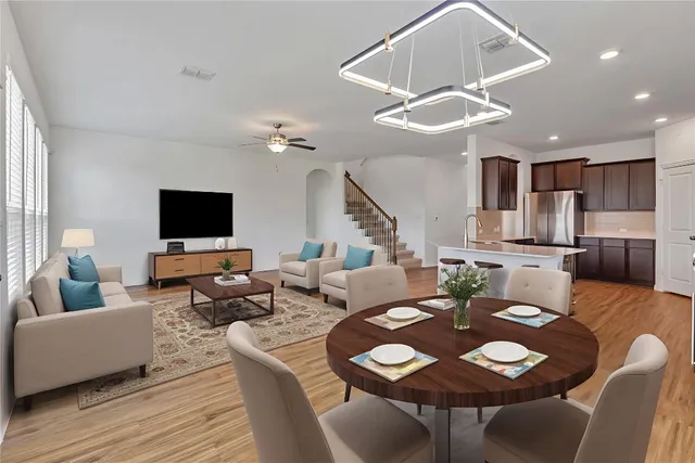 a living room with furniture a flat screen tv and kitchen view