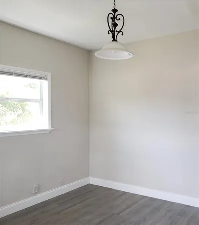 a view of a room with a window and wooden floor