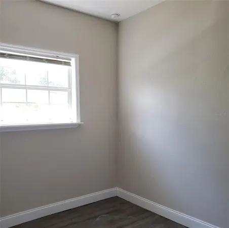 a view of a small space with wooden floor and a window