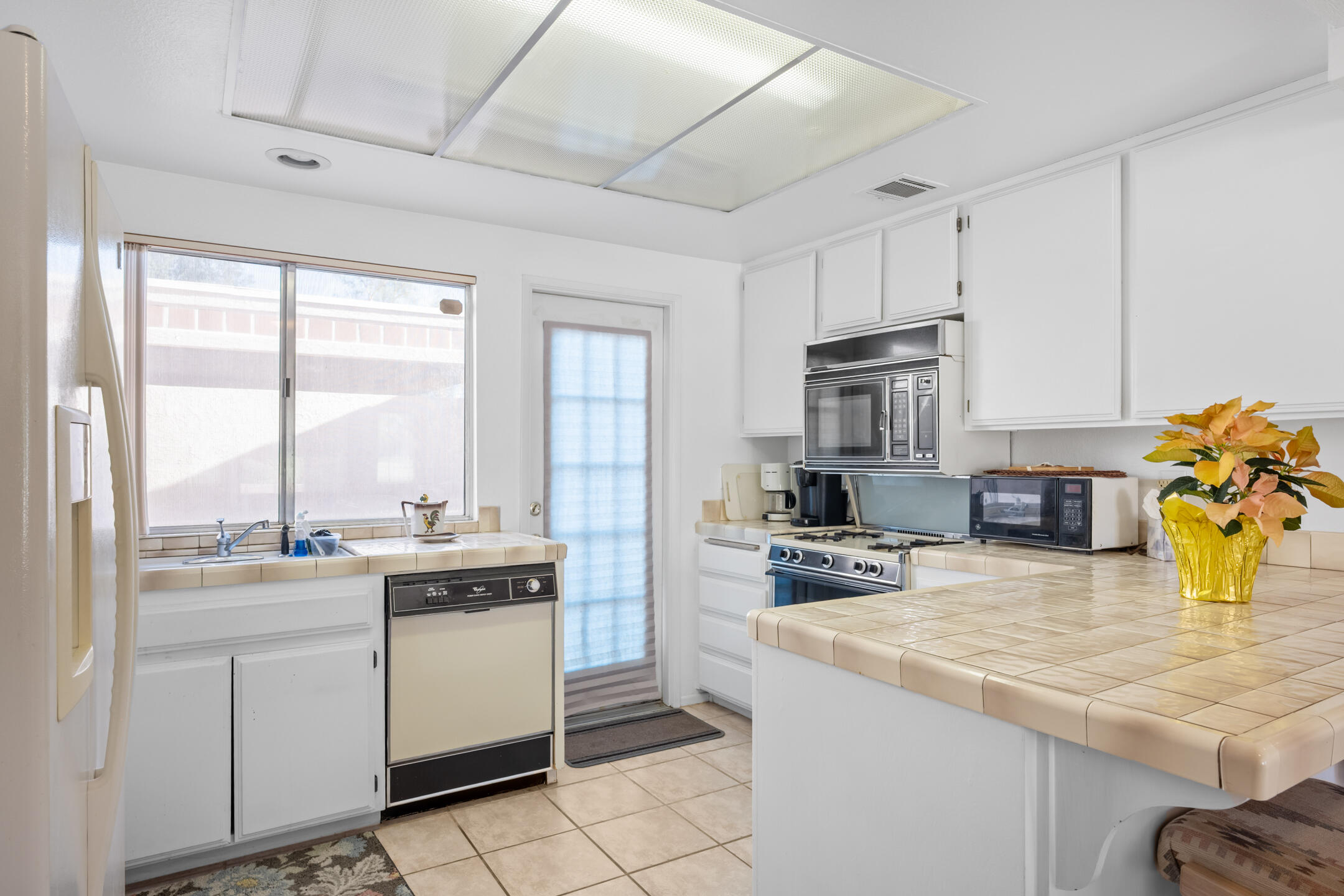 49211 Douglas Street Indio, CA 92201 - Photo 13 of 44 a kitchen with a sink stove and cabinets