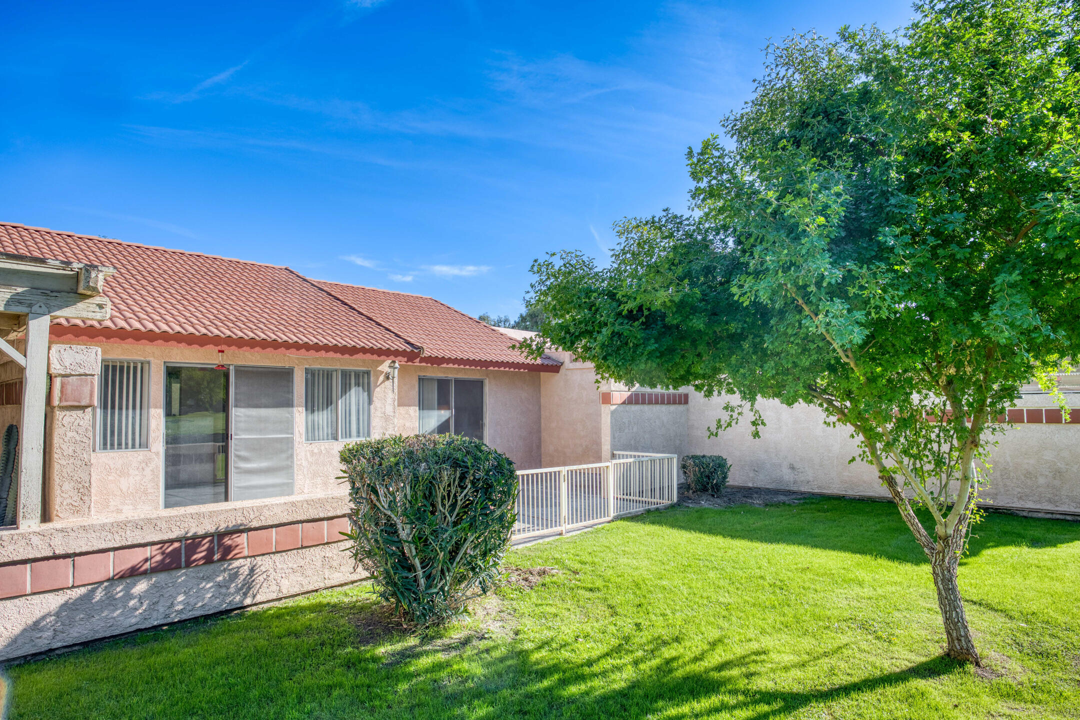 49211 Douglas Street Indio, CA 92201 - Photo 30 of 44 a view of a house with backyard and a tree
