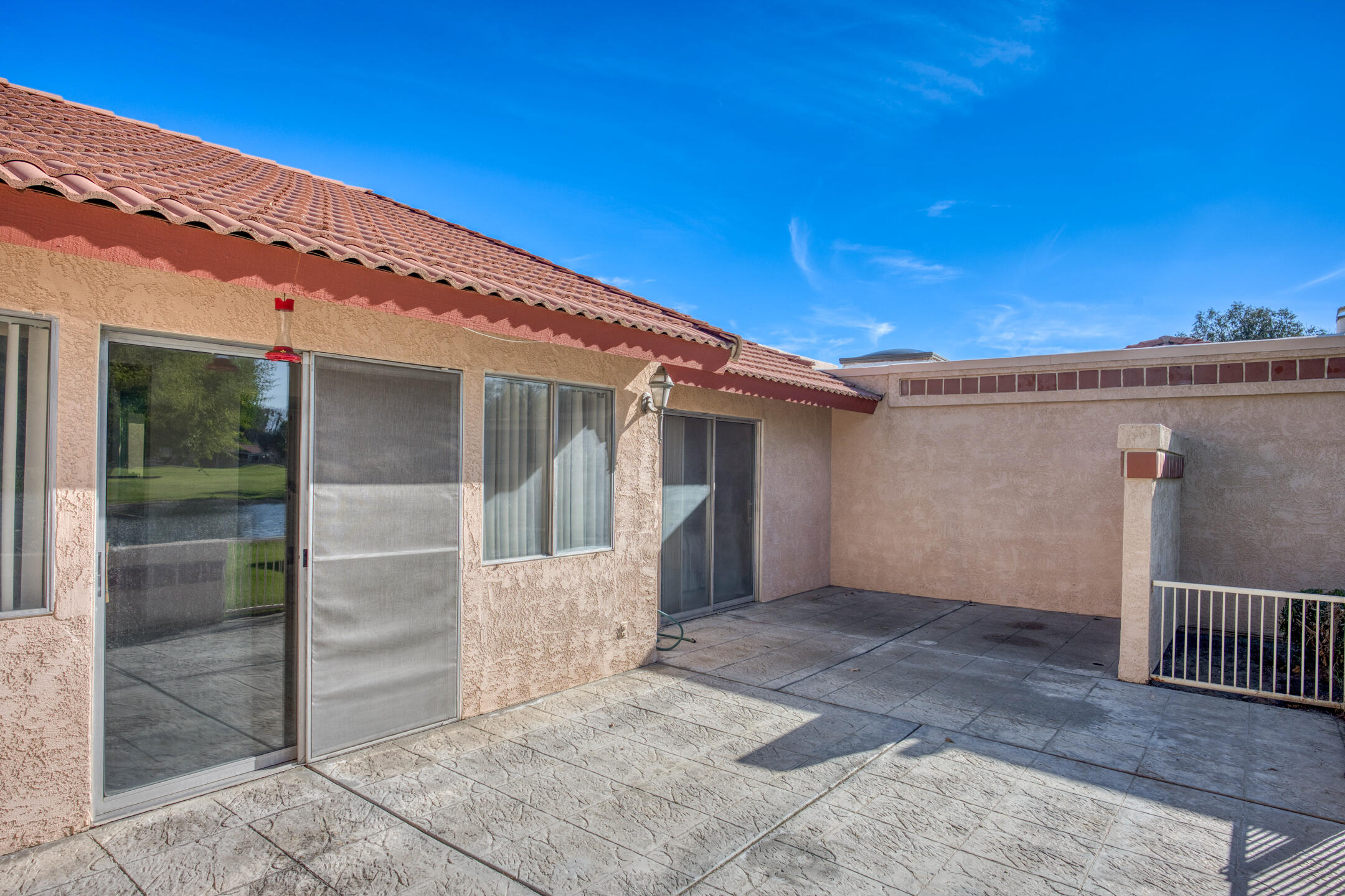 49211 Douglas Street Indio, CA 92201 - Photo 36 of 44 a view of a house with a wooden deck and floor to ceiling window