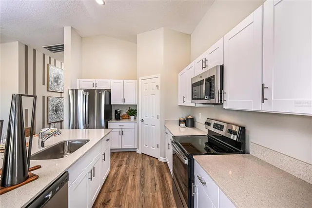 a kitchen with stainless steel appliances a refrigerator sink and microwave