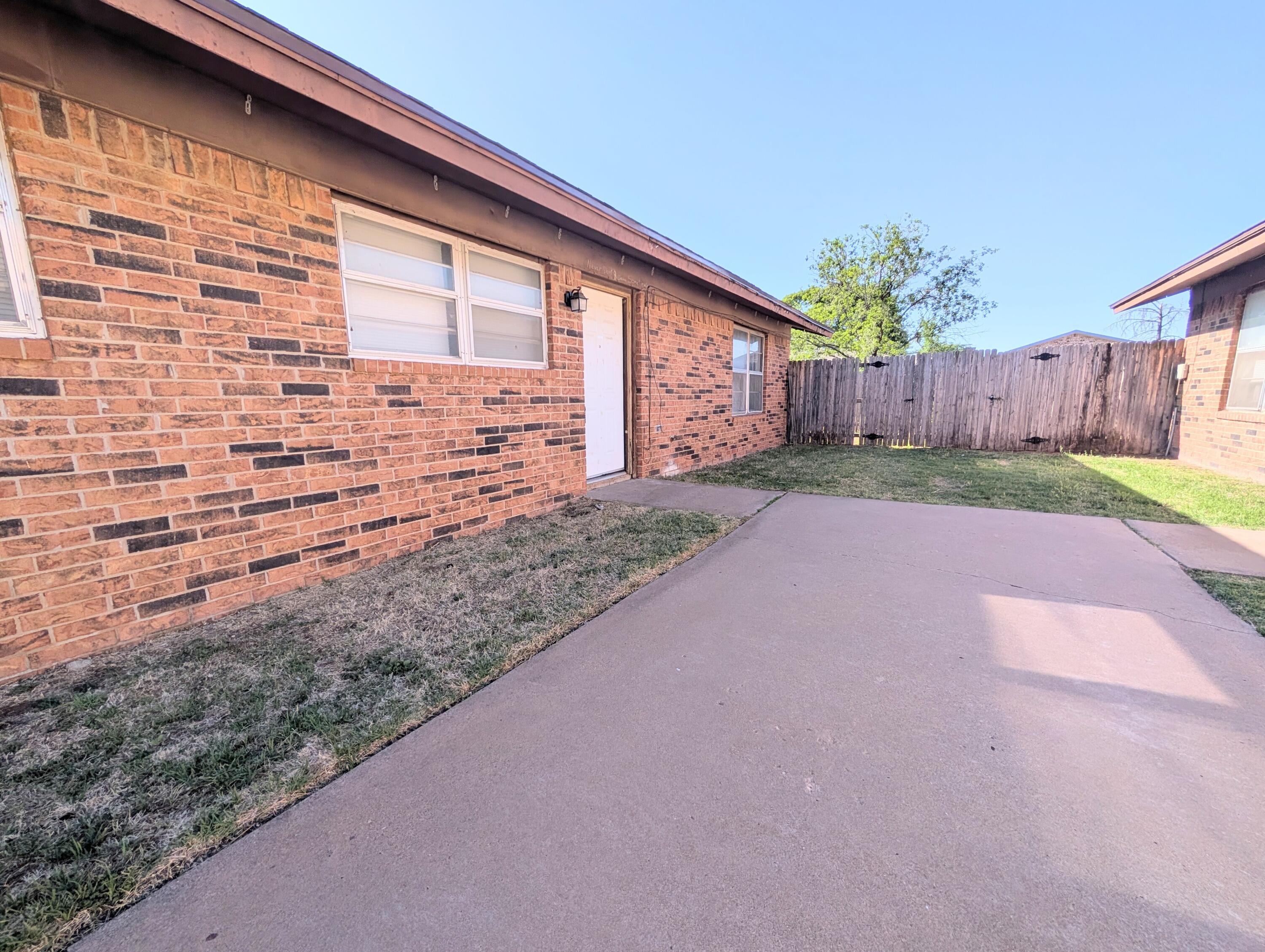 6509 21st Street, Unit B Lubbock, TX 79407 - Photo 1 of 9 a view of a backyard with wooden fence