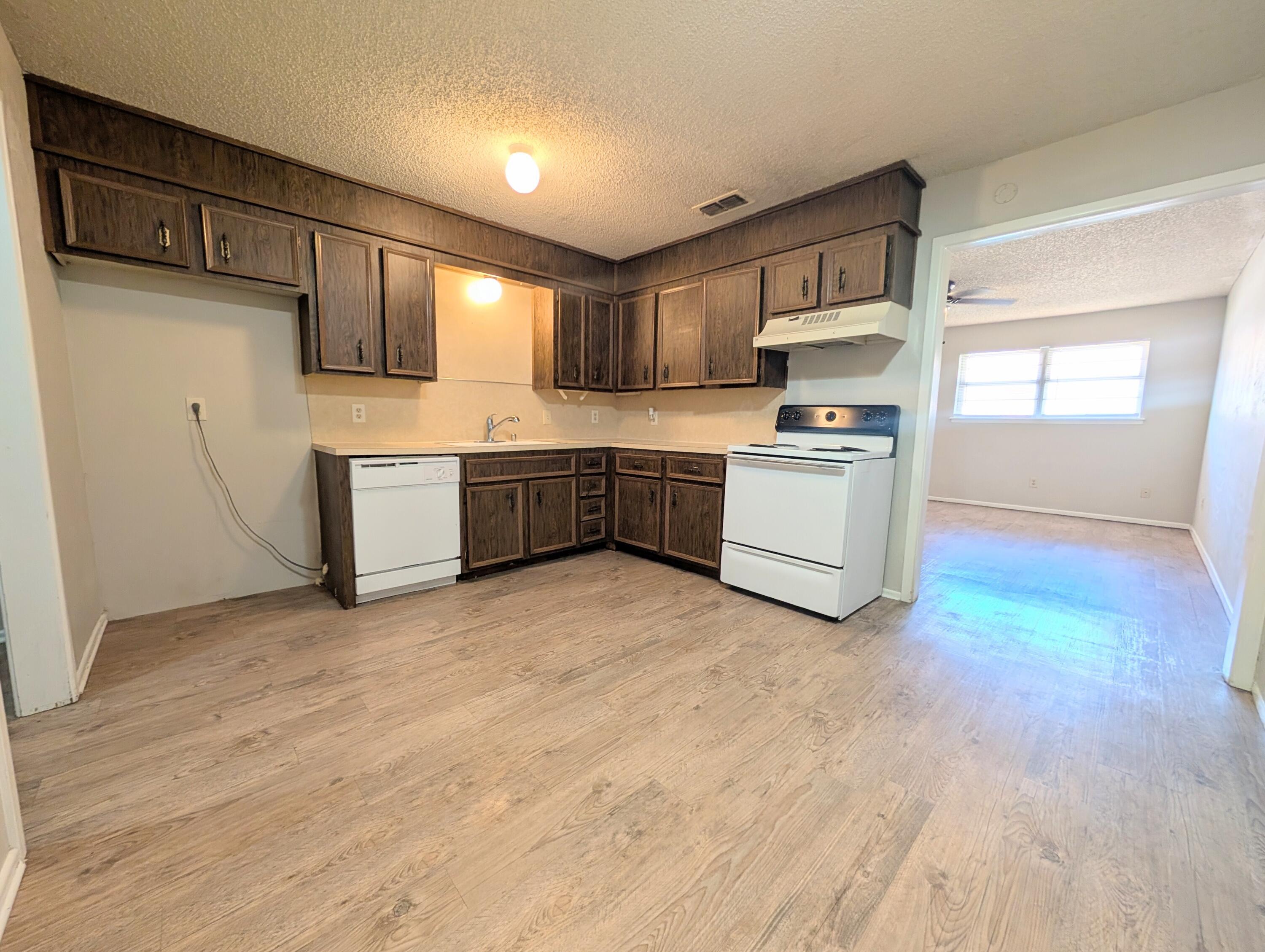 6509 21st Street, Unit B Lubbock, TX 79407 - Photo 3 of 9 a kitchen with stainless steel appliances granite countertop a stove a sink and a refrigerator