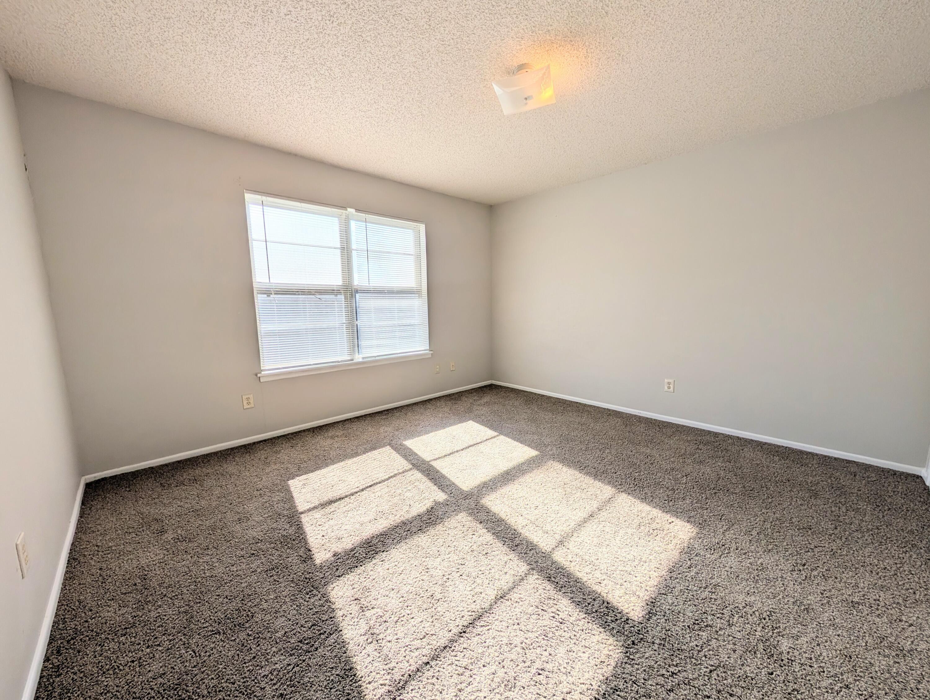 6509 21st Street, Unit B Lubbock, TX 79407 - Photo 4 of 9 an empty room with wooden floor and windows