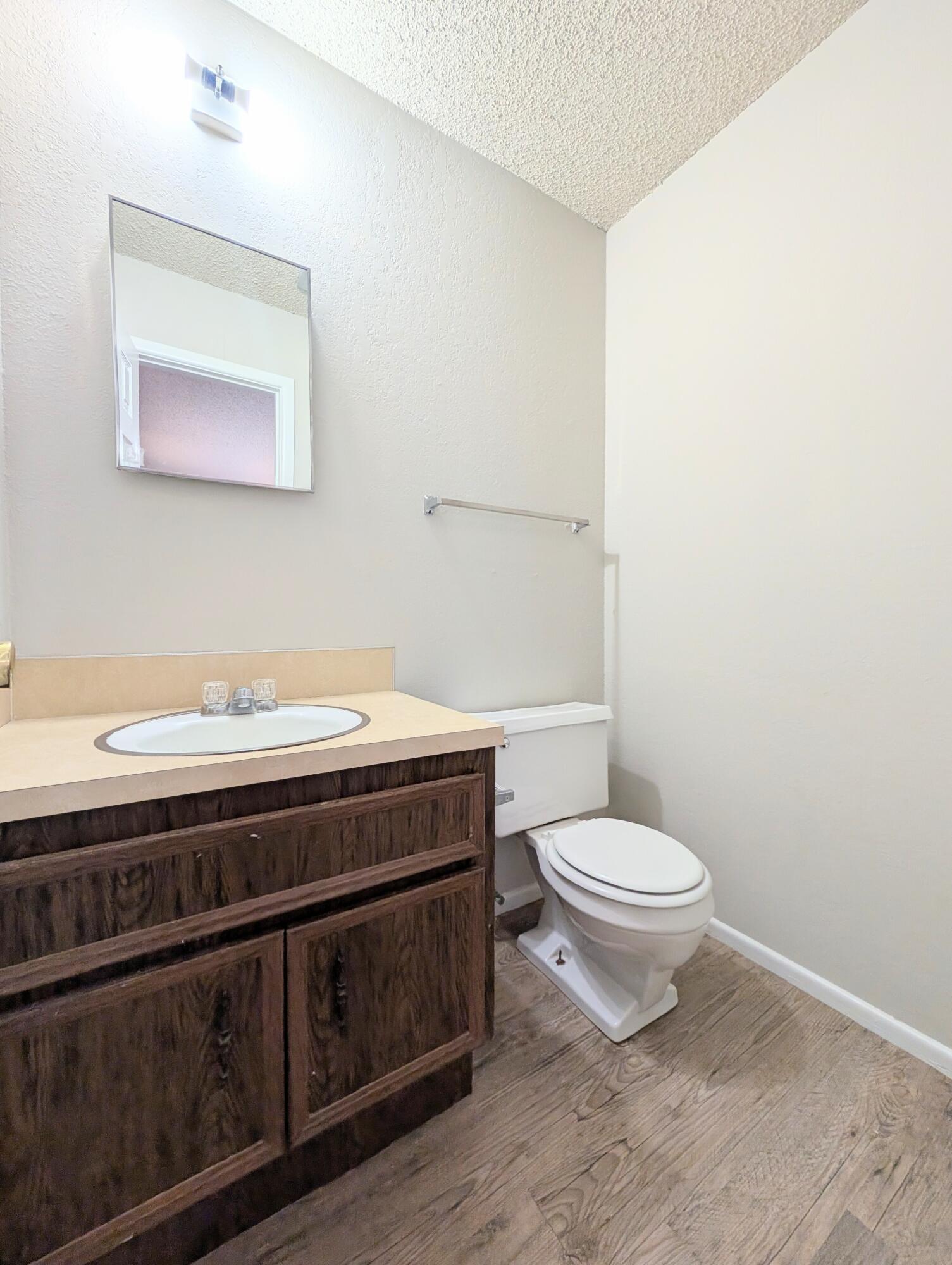6509 21st Street, Unit B Lubbock, TX 79407 - Photo 5 of 9 a bathroom with a toilet a sink and mirror