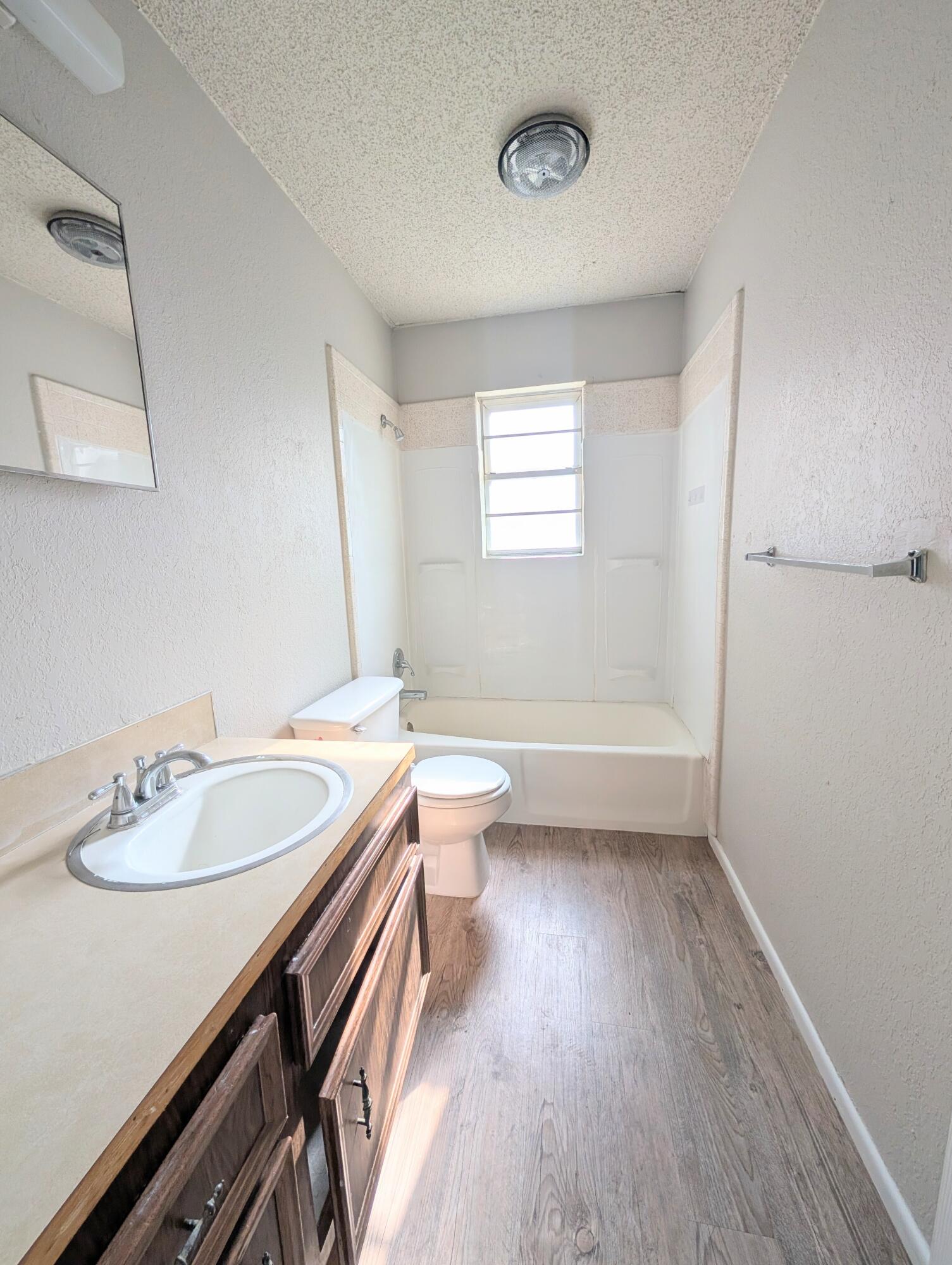 6509 21st Street, Unit B Lubbock, TX 79407 - Photo 7 of 9 a bathroom with a sink a toilet a mirror and shower