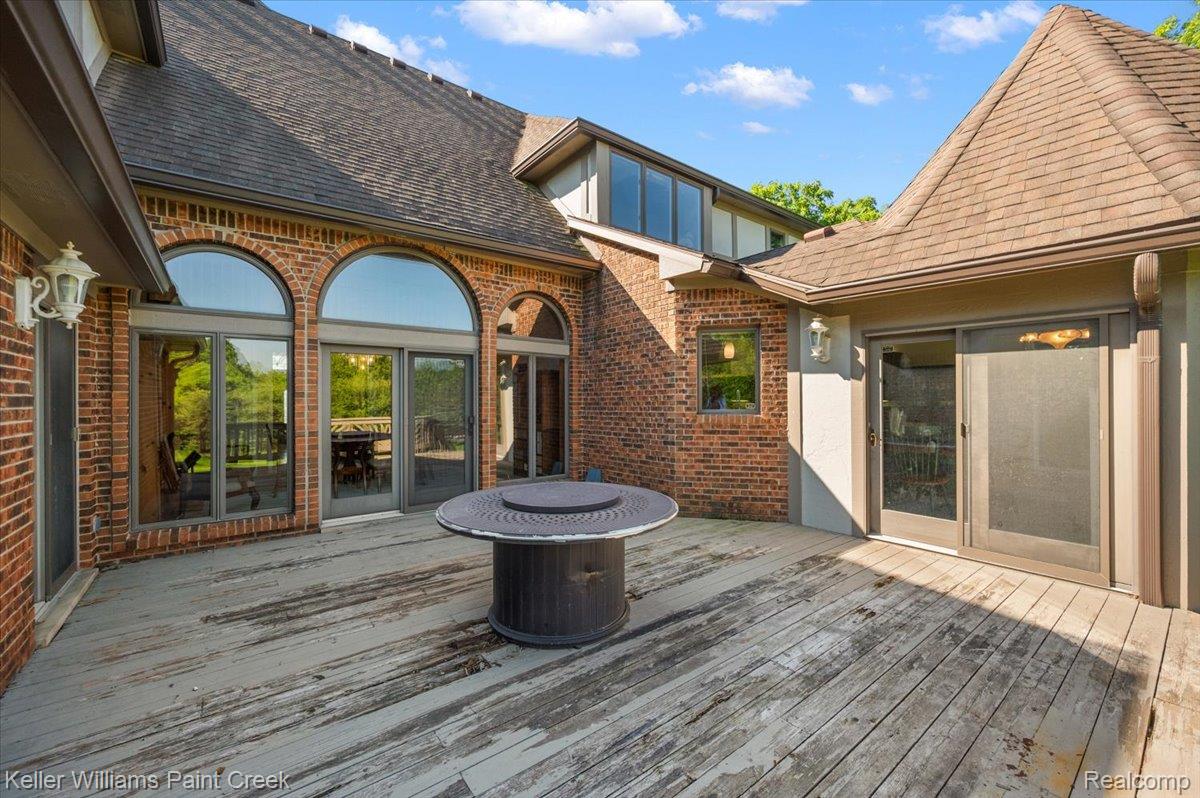 69069 Campground Road Romeo, MI 48065 - Photo 14 of 78 Expansive outdoor deck area featuring a red brick exterior, multiple arched windows, and a sliding glass door