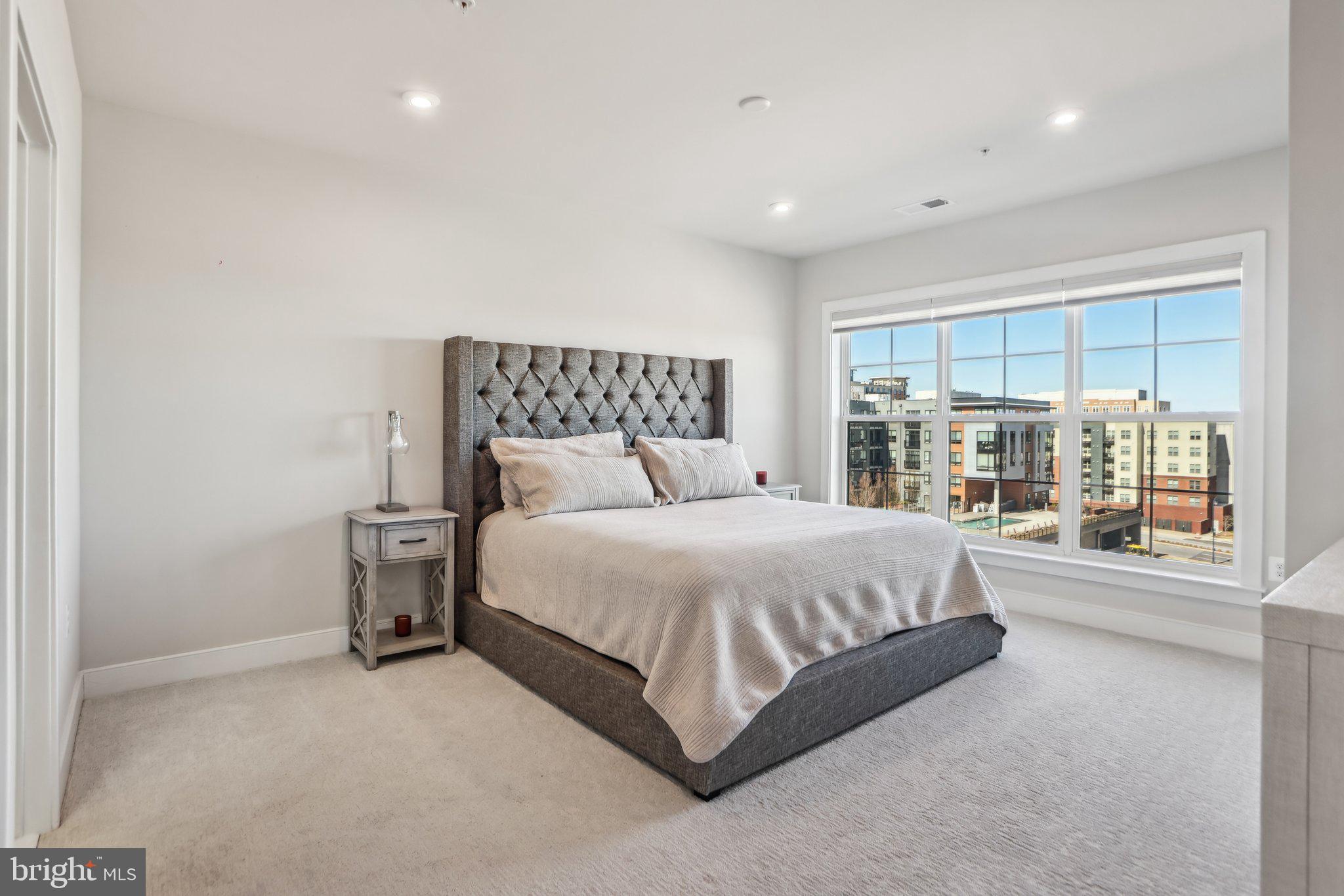 100 St Ives Place, Unit 306 Oxon Hill, MD 20745 - Photo 17 of 32 a large bed sitting in a room next to a large window