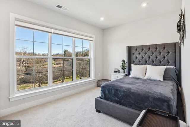 a spacious bedroom with a bed and a large window