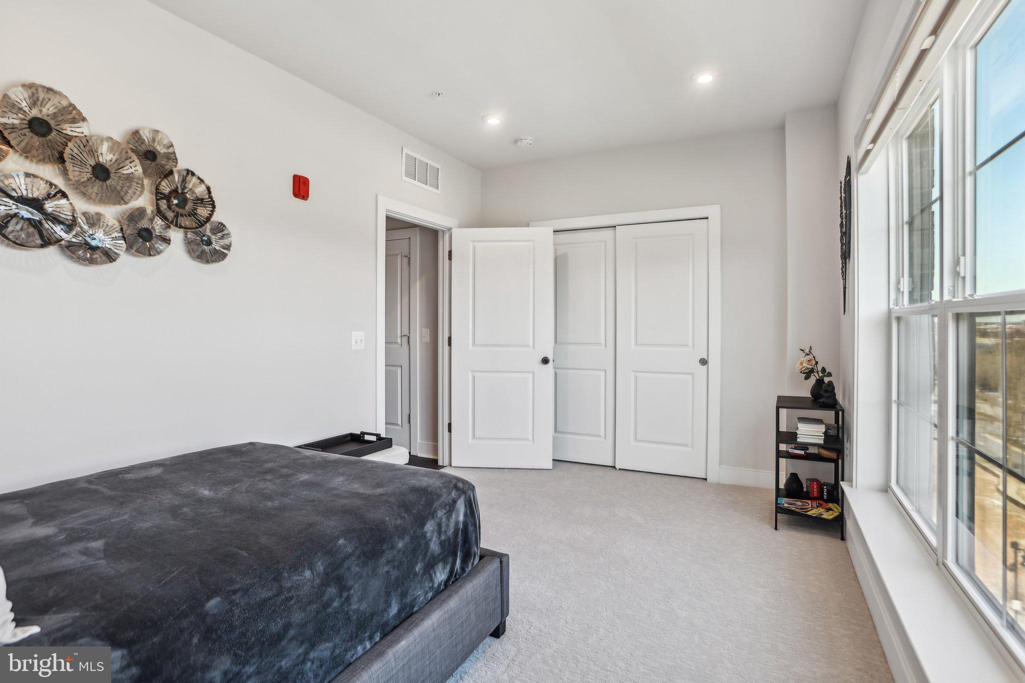 100 St Ives Place, Unit 306 Oxon Hill, MD 20745 - Photo 26 of 32 a spacious bedroom with a bed and a window