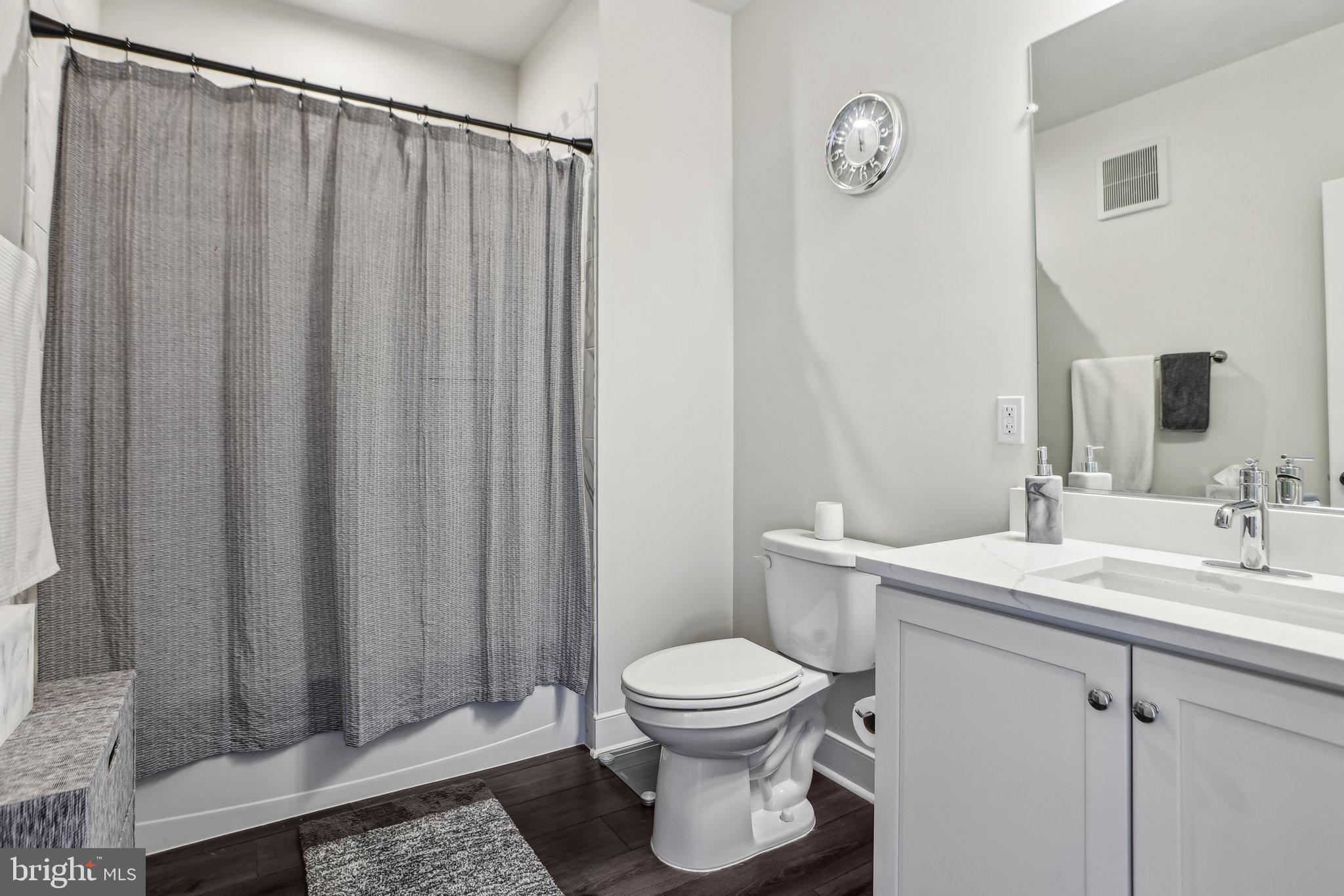 100 St Ives Place, Unit 306 Oxon Hill, MD 20745 - Photo 27 of 32 a bathroom with a toilet a sink and a mirror