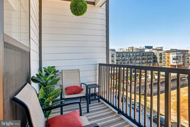 a balcony with wooden floor table and chair