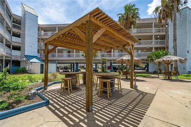 a view of a patio with table and chairs potted plants and palm trees