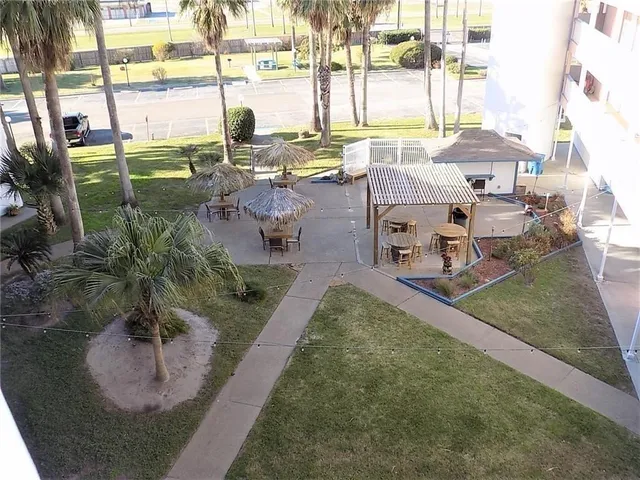 a living room with patio furniture and floor to ceiling windows