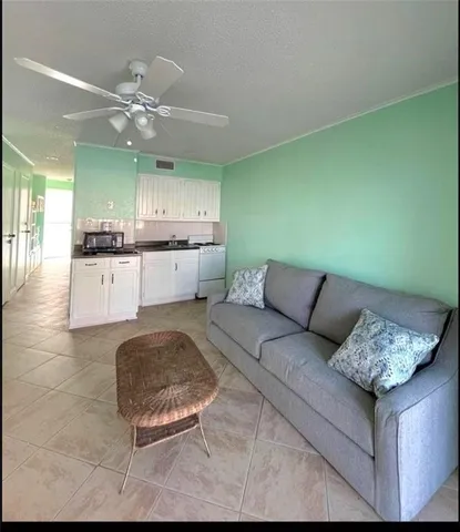 a living room with furniture and kitchen view