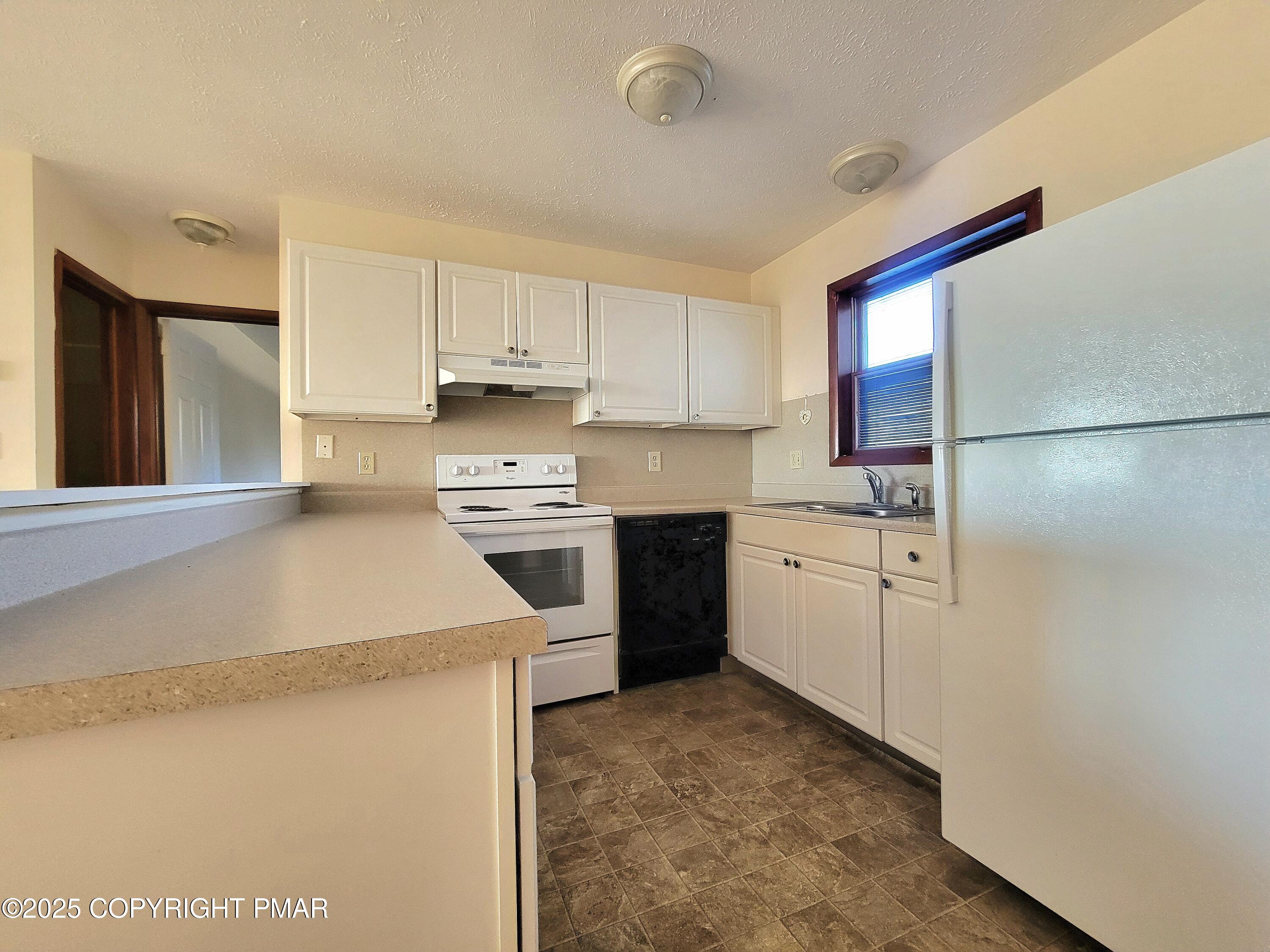 115 Foxfire Drive, Unit 306 Mount Pocono, PA 18344 - Photo 4 of 19 a kitchen with a sink a stove and refrigerator