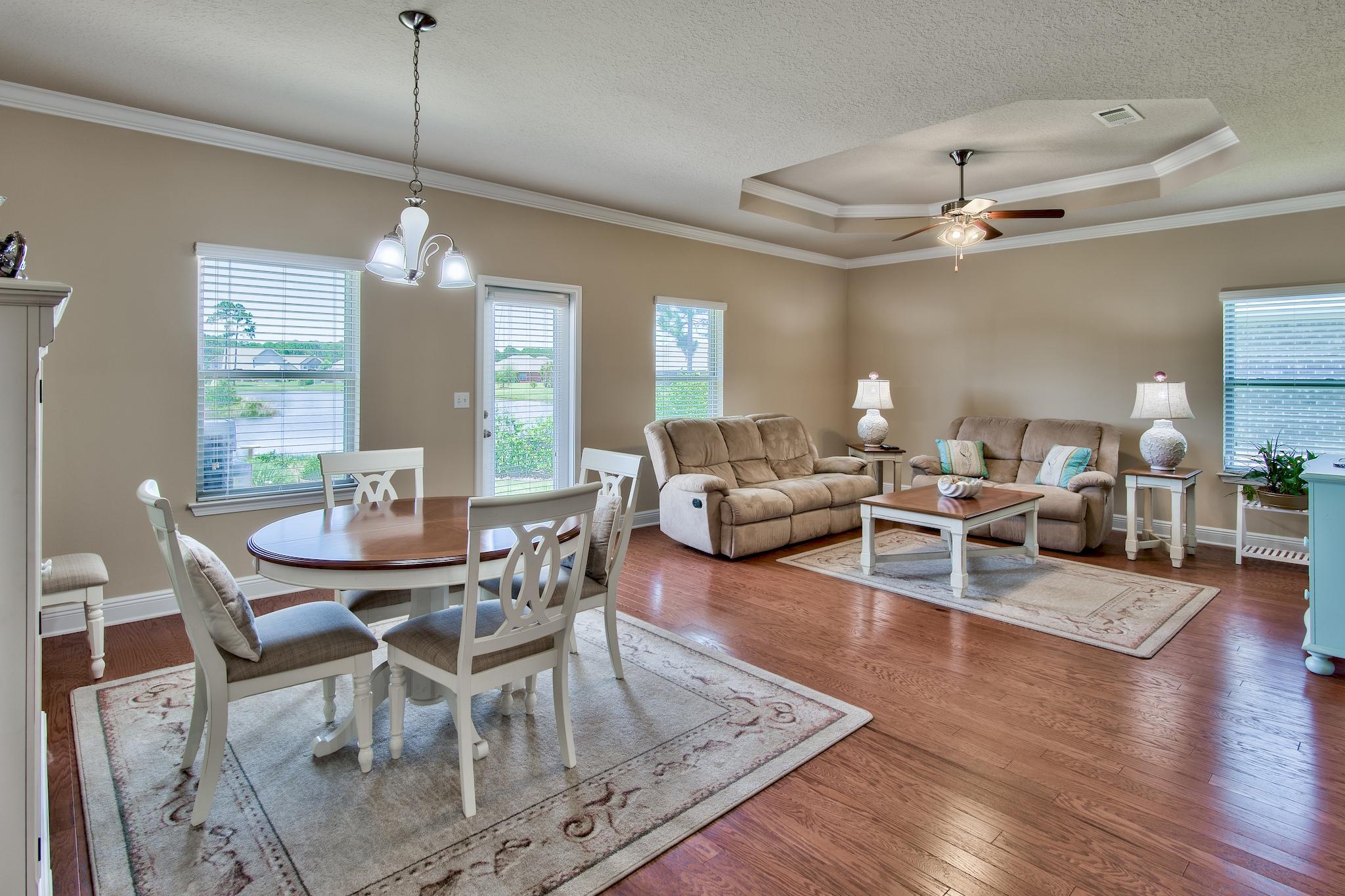 447 Pin Oak Loop Santa Rosa Beach, FL 32459 - Photo 4 of 46 a view of a dining room and livingroom with furniture wooden floor a chandelier