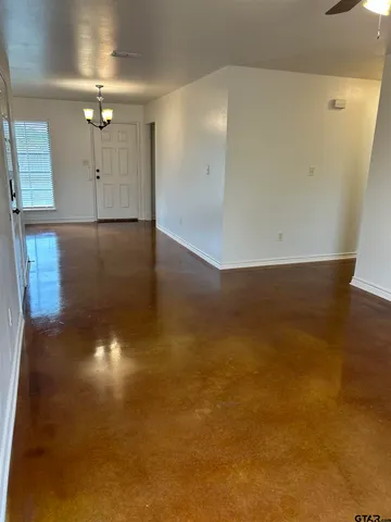 wooden floor in an empty room with a kitchen
