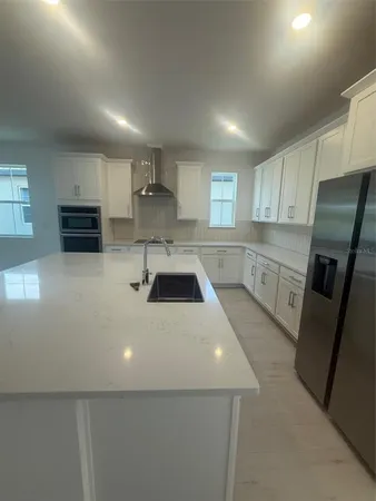 a kitchen with stainless steel appliances a refrigerator sink and microwave