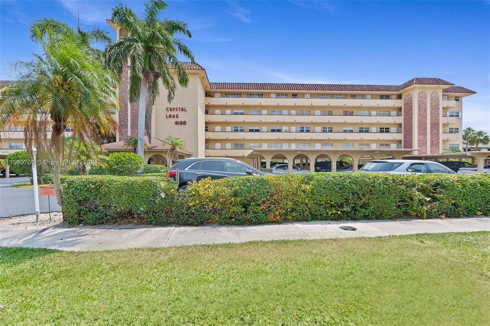 a view of a large building with a big yard and palm trees